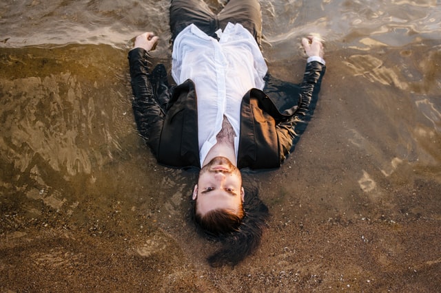 мужчина лежит на песке